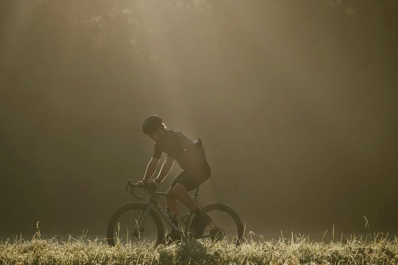 Cycliste dans la brume matinale, au bord d’un champ