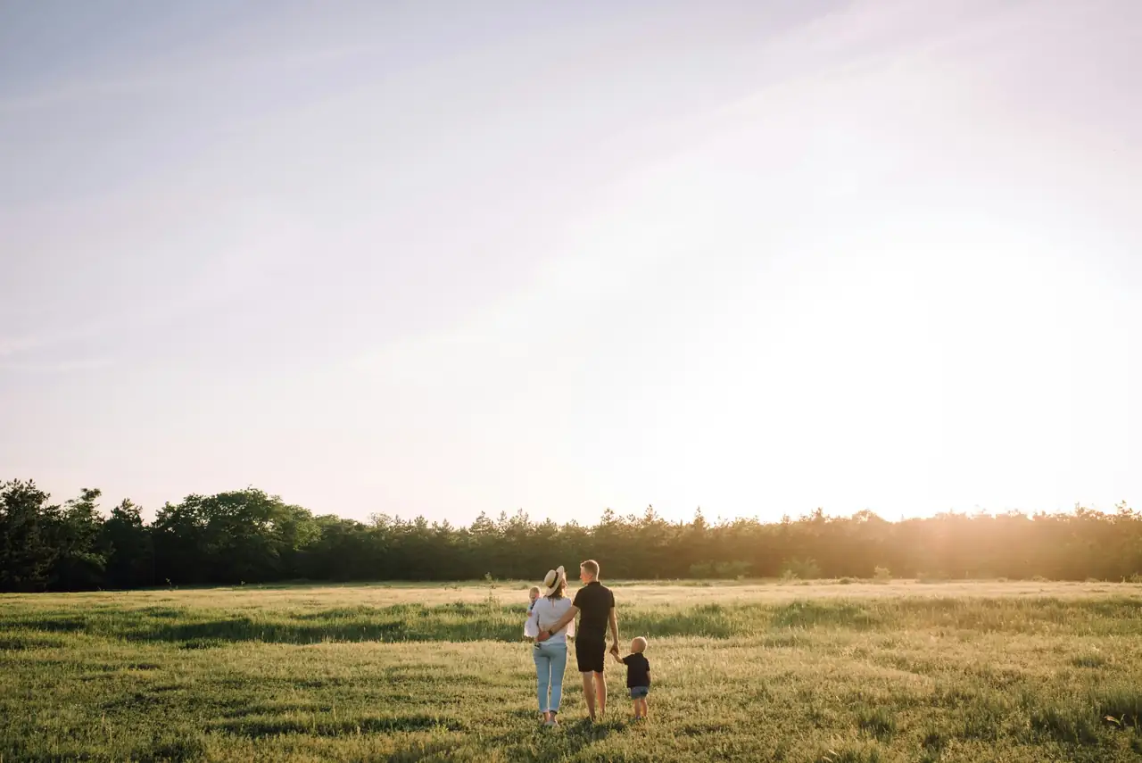 Famille qui marche dans un champ au coucher du soleil