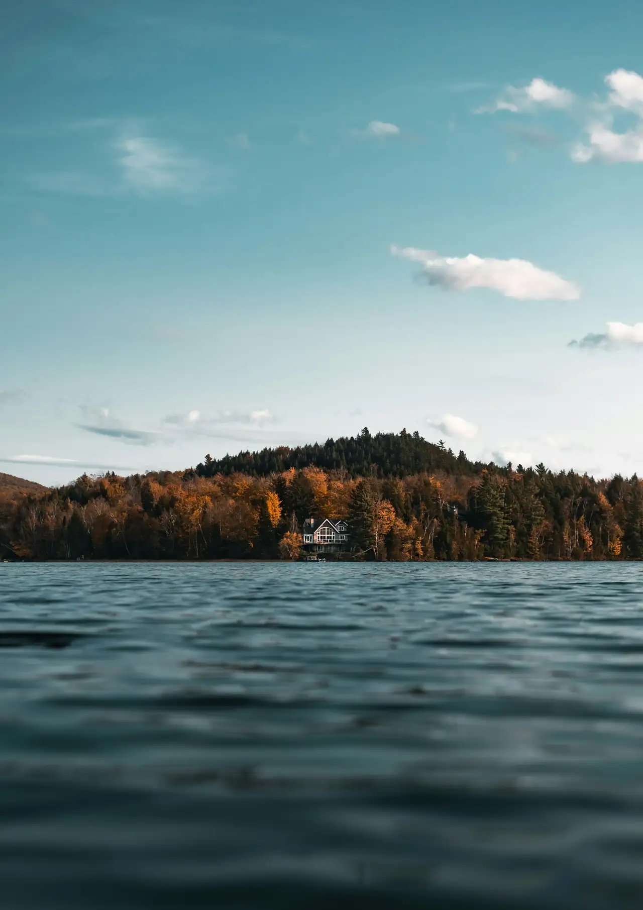 Maison au bord d’un lac, entourée de forêt