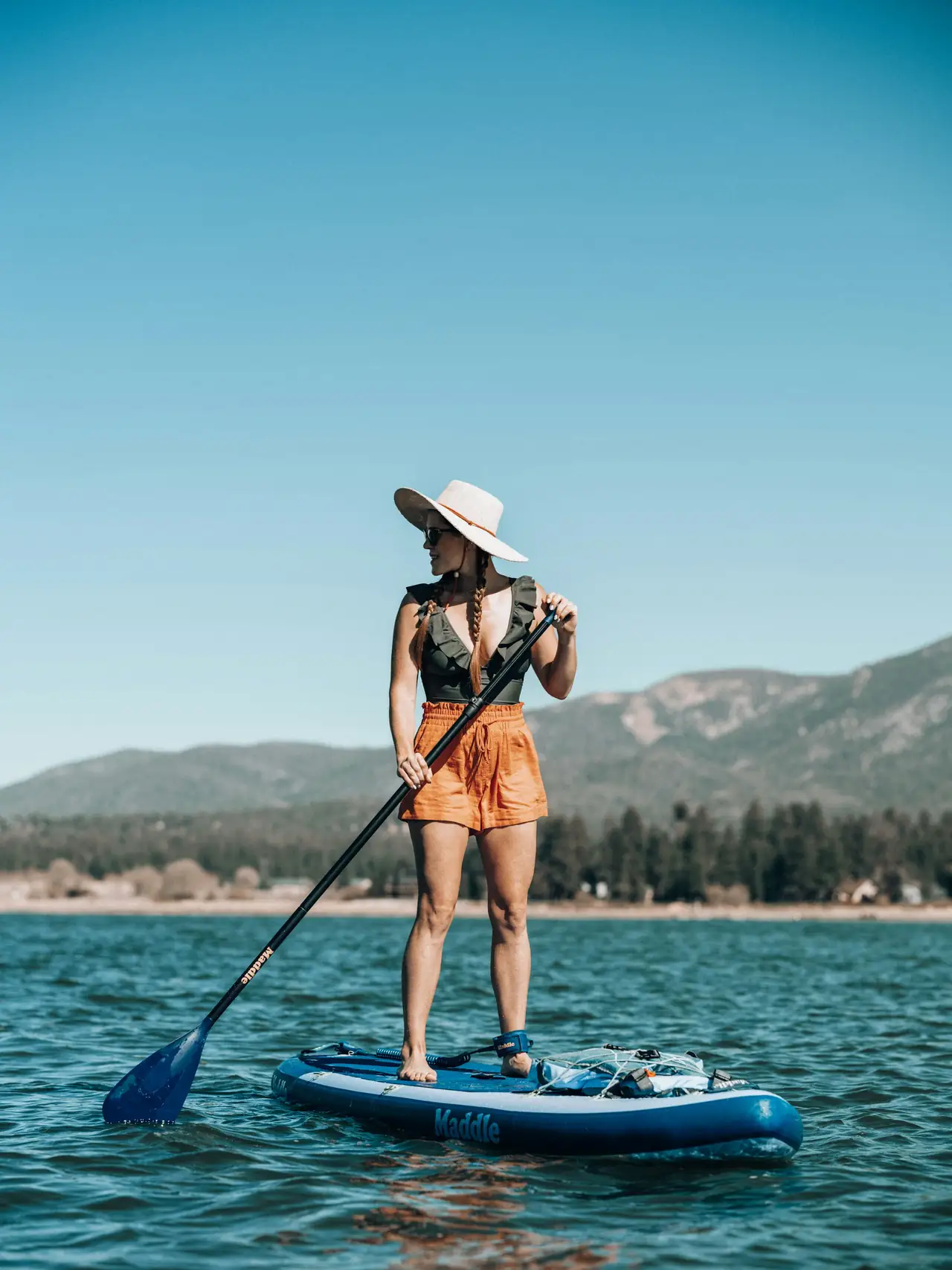 Femme en planche à pagaie sur un lac